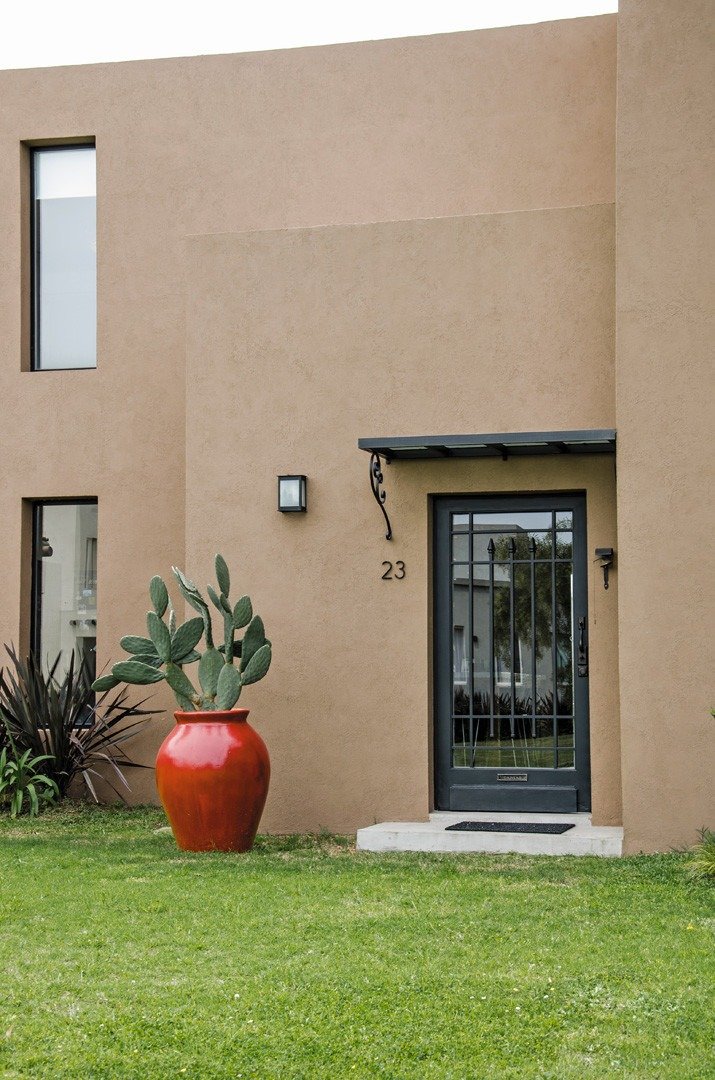 Fachada con color predominante Beige del Proyecto Casa 12 por Estudio  Martínez Nespral